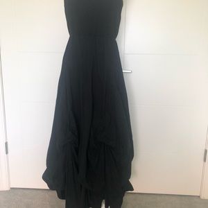 Black strapless dress with draped hemline.